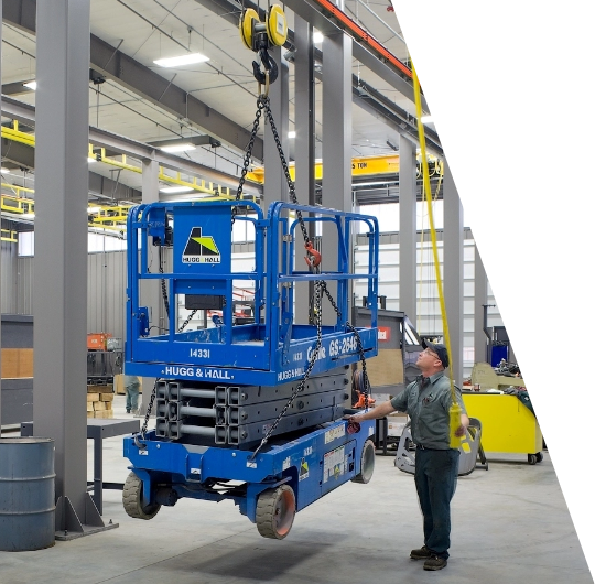 Image of man hoisting a cherry picker in a factory.