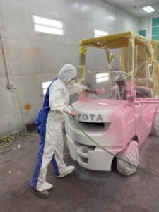 Victoria Parrish painting the Toyota forklift pink. 