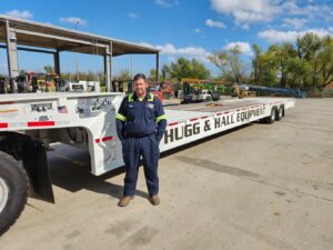 Drew Logsdon standing in front of a Hugg & Hall delivery trailer.