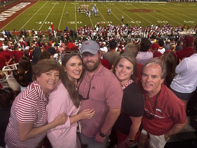 Sarah White (fourth from left) with her mother, sister-in-law, brother, and father (left-to-right). They are attending a Razorback football game.