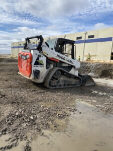 Bobcat rental equipment track loader working safely in muddy conditions